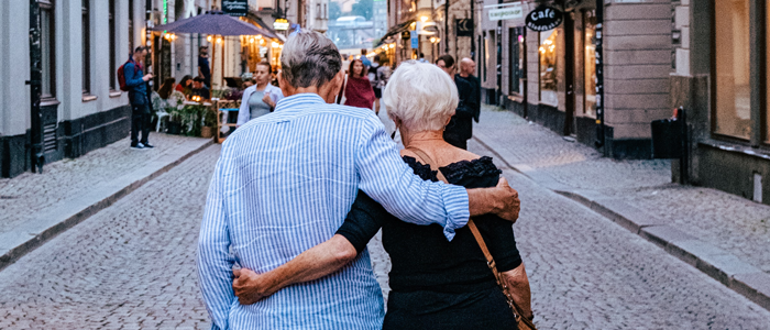 Ett par som promenerar på en kullerstensgata i Stockholm.