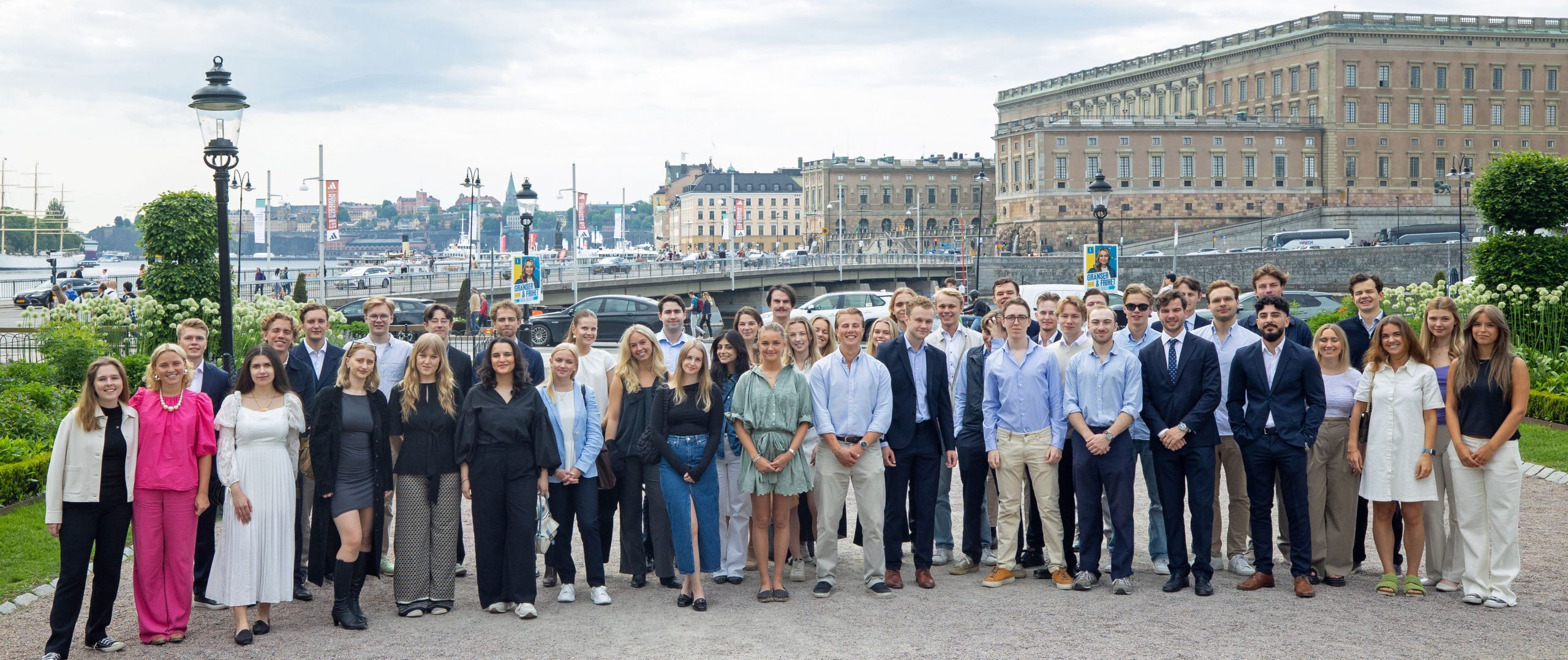 Gruppfoto av stipendiater från Grosshandelssocieteten framför Stockholms slott.