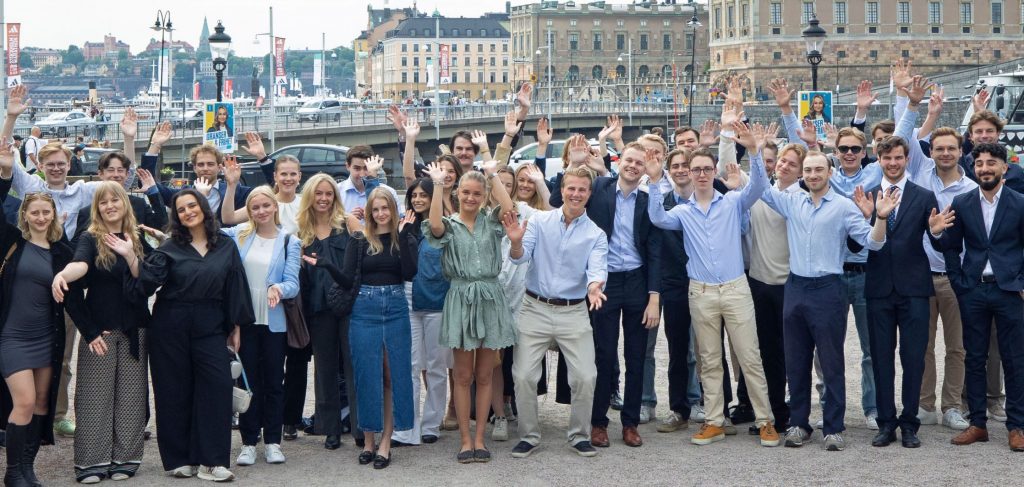 Gruppfoto av stipendiemottagare från Stockholms Borgerskap framför en stadsutsikt i Stockholm.
